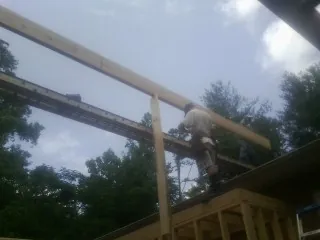 Carpenter setting a ridge beam over a new addition frame — Ice Dam Removal by Roofing Brothers in Shipshewana