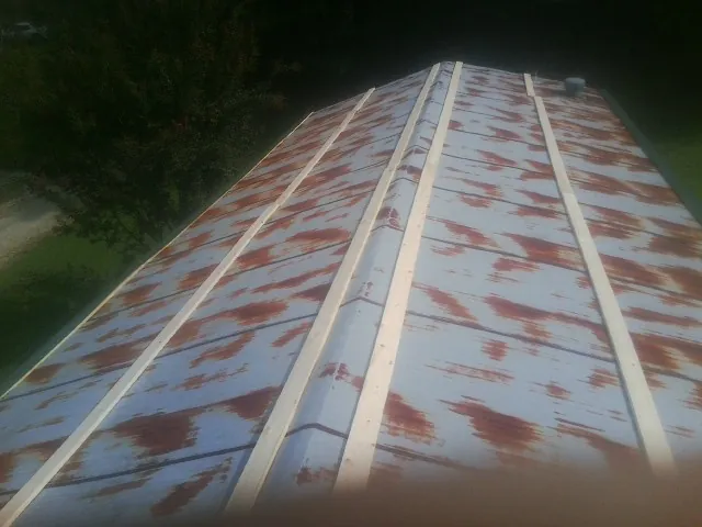 Rusted metal roof panels with new wood purlins before replacement — Storm Damage Roof Repair in Shipshewana by Roofing Brothers