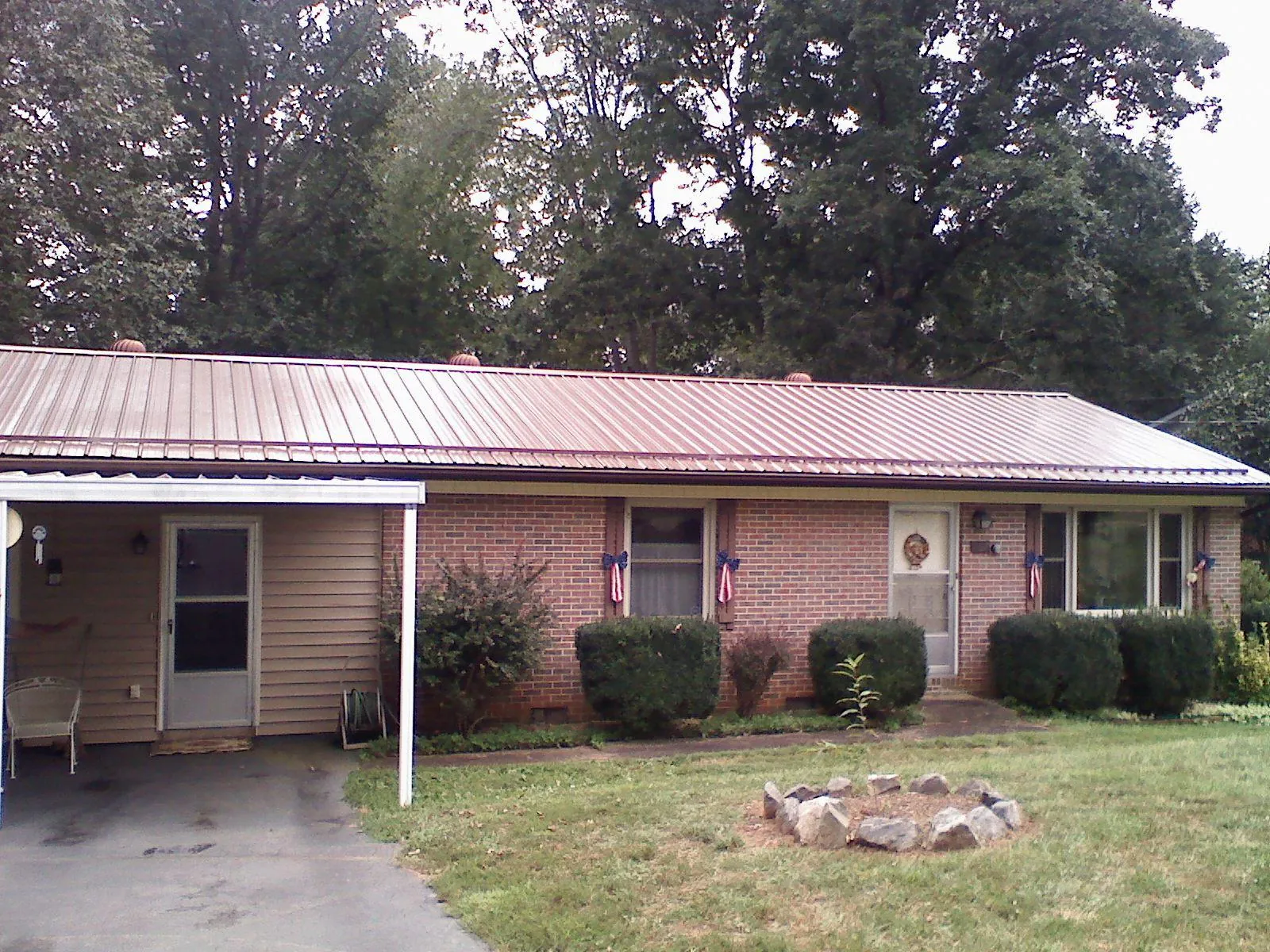 Bronze metal roof and carport on a brick ranch home — Roof Repair work by our crew in Shipshewana